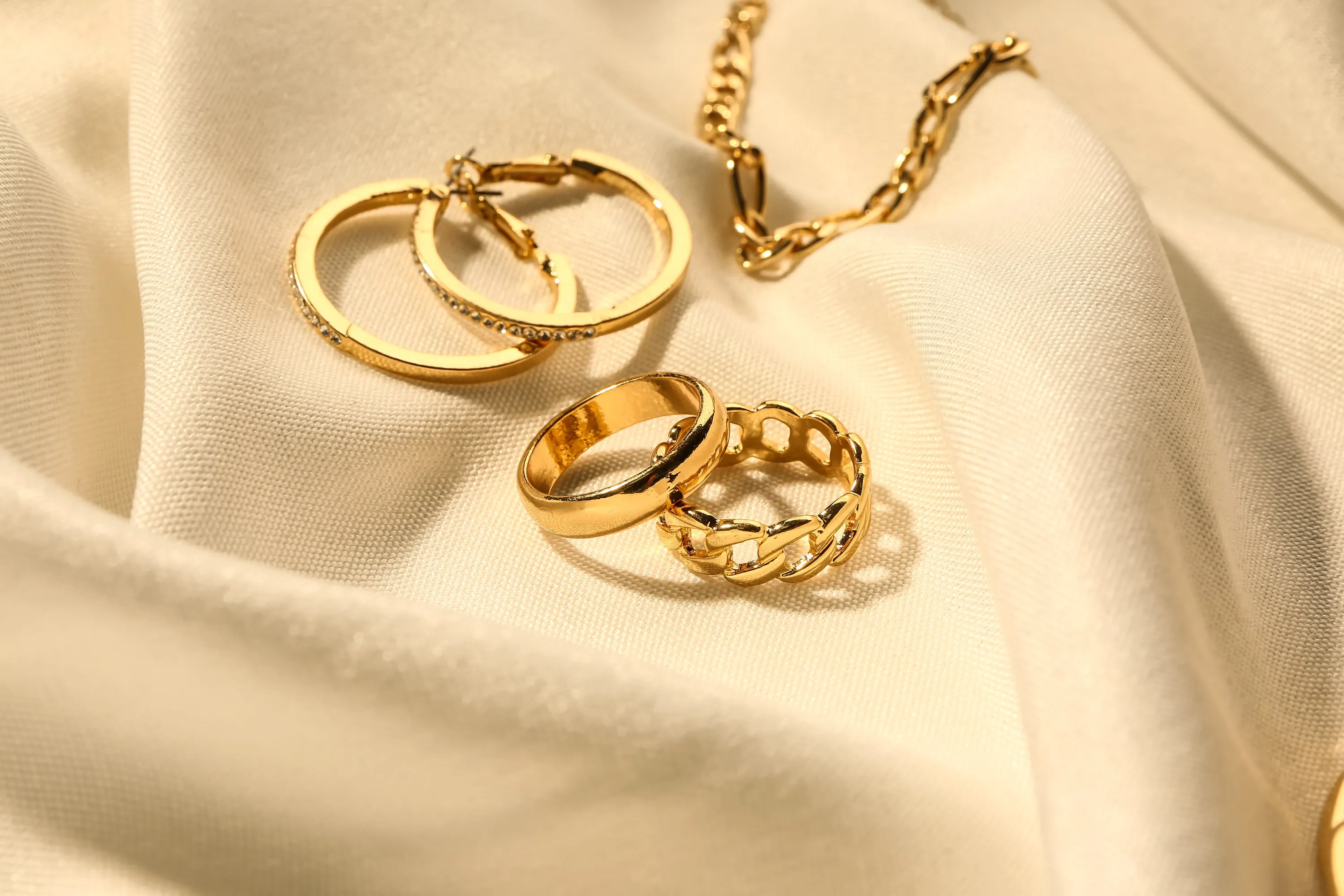Goldschmuck – Ringe, Kette und Creolen auf Seide – Schmuckankauf bei Juwelier Böhnel